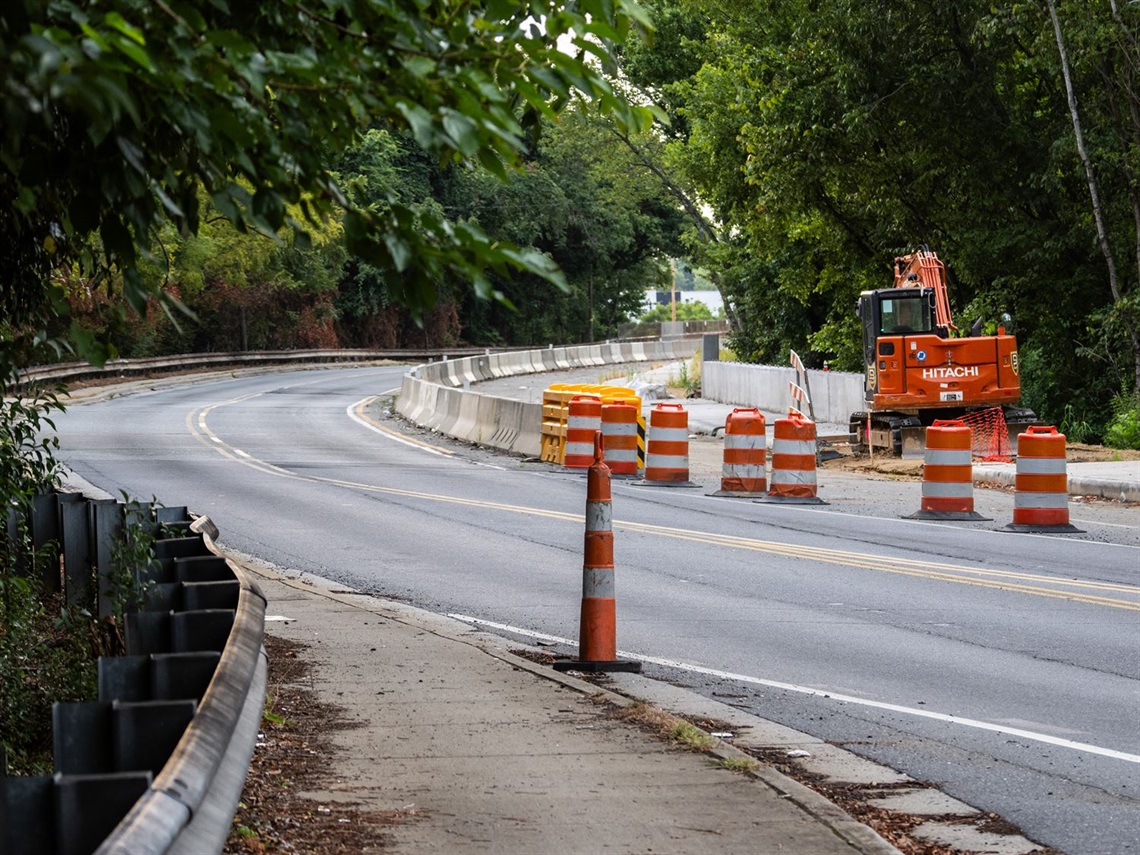 A street view of orange construction cones along a city road.