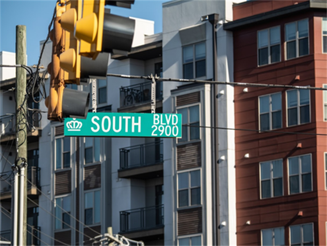 A street view of a sign reading South Boulevard against an apartment complex