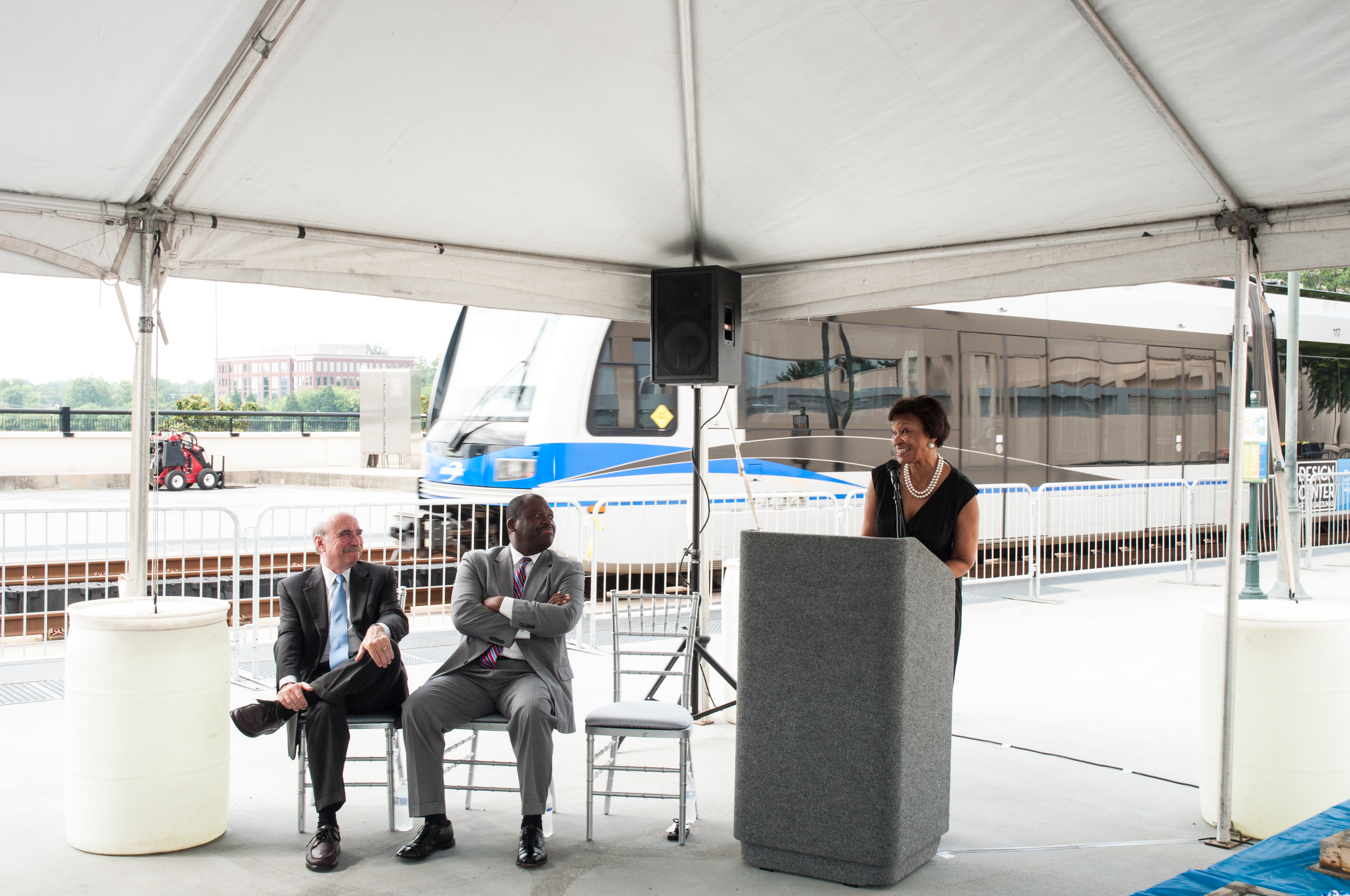 Carolyn Flowers standing behind a gray podium, speaking at a CATS related event