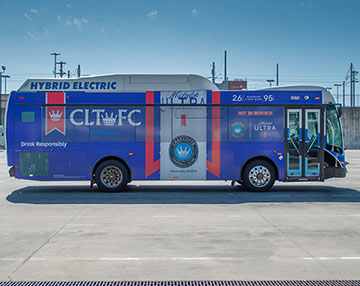 Cats hybrid electric bus with advertisement on it from ultra and clt fc