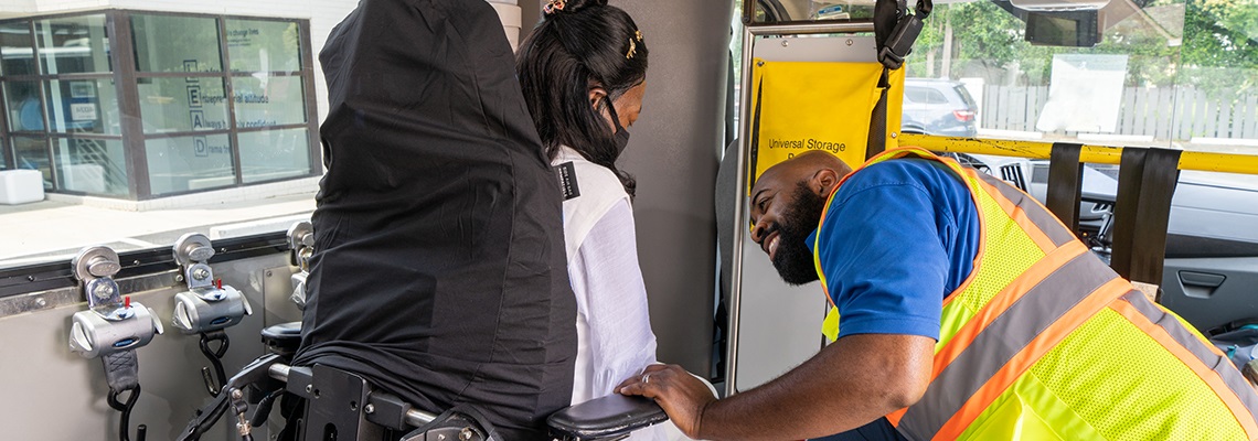 Paratransit driver helping a rider in a wheelchair on the paratransit bus