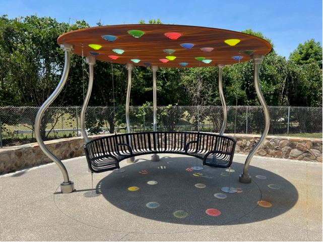 A round canopied structure with a swinging curved bench