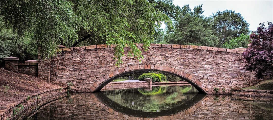 A stone bridge spanning a pond in Freedom Park