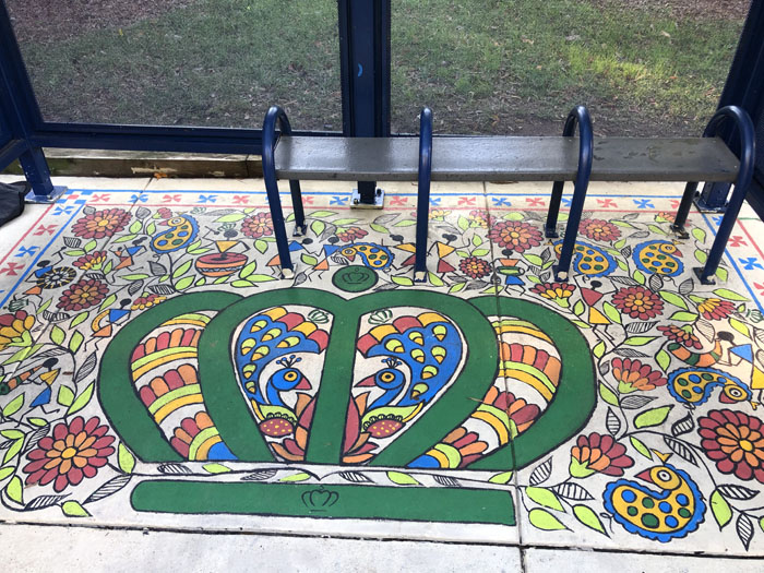 image of a bus stop bench and a mural featuring the crown logo