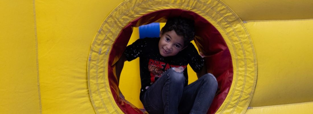 Kid having fun in bounce house at SIA community event.