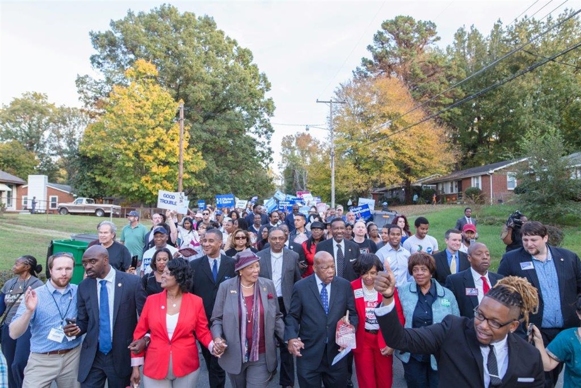 Civil rights leader John Lewis and NC Congresswoman Alma Adams surrounded by a large group of activists lead a march through Charlotte's West side