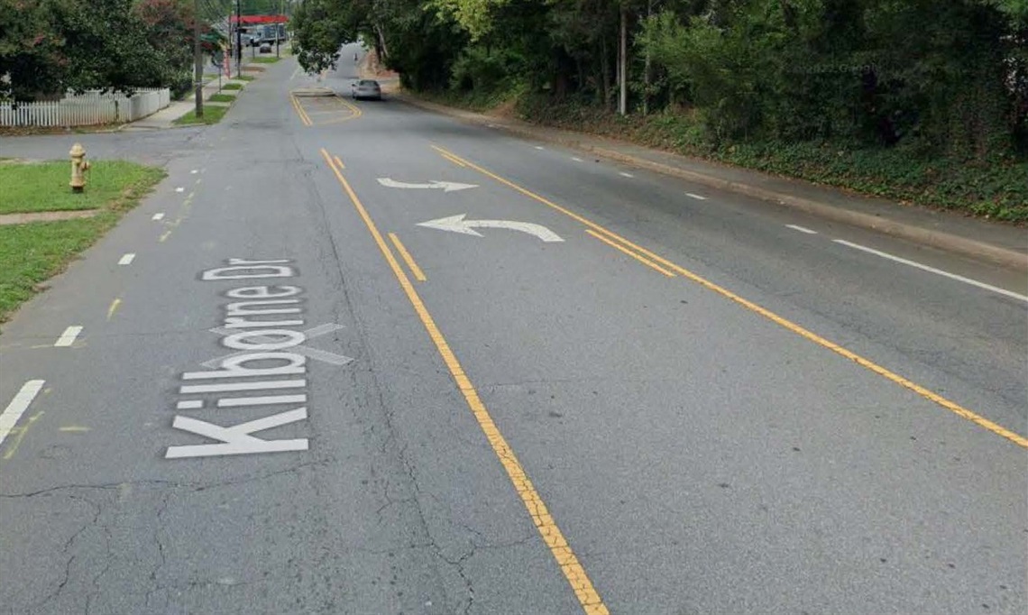 Image of existing roadway with one travel lane on either side and a turning lane in the middle