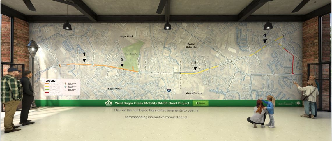 a large map of the project area covers a wall in a room with people examining it