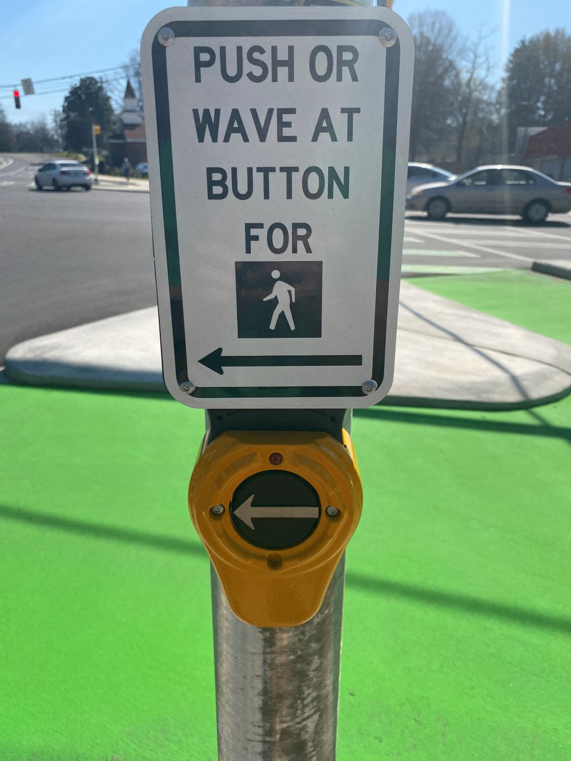 An accessible pedestrian signal with a sign above it that says, 