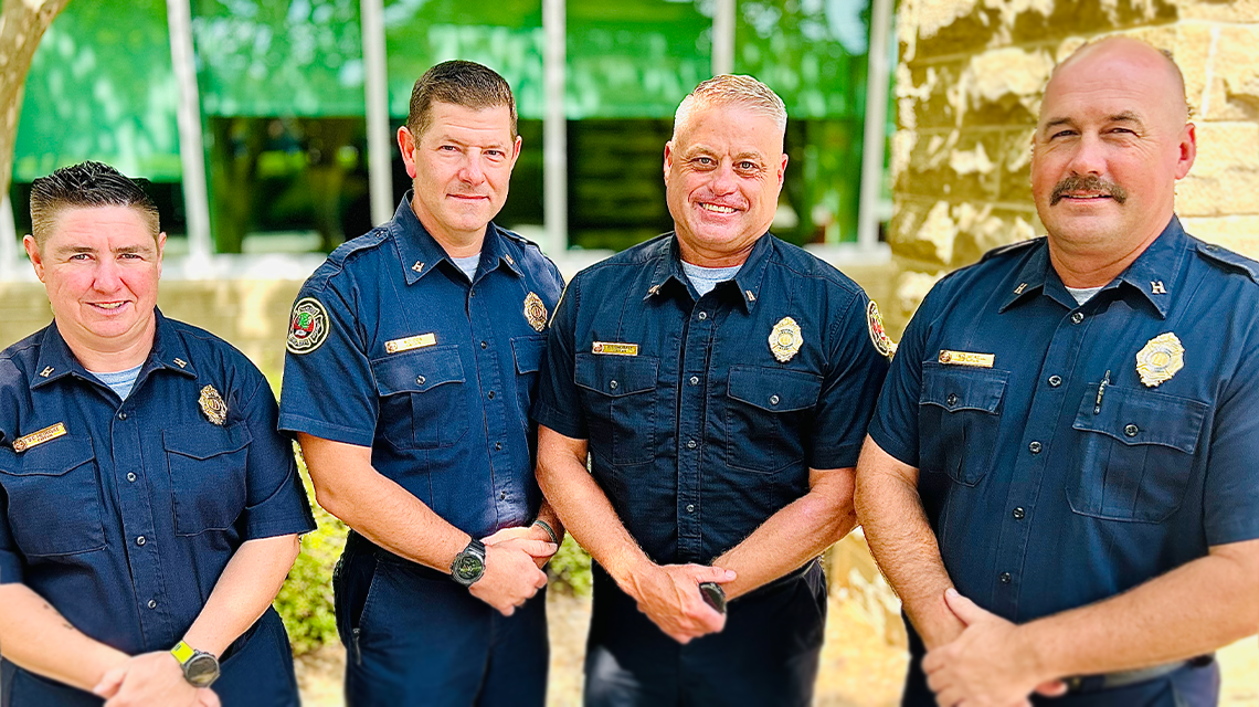 Captains Denise Petraske, Michael Cox, Terence Shumate, and Kevin Newell  stand together outside the Charlotte Fire Training Academy, 