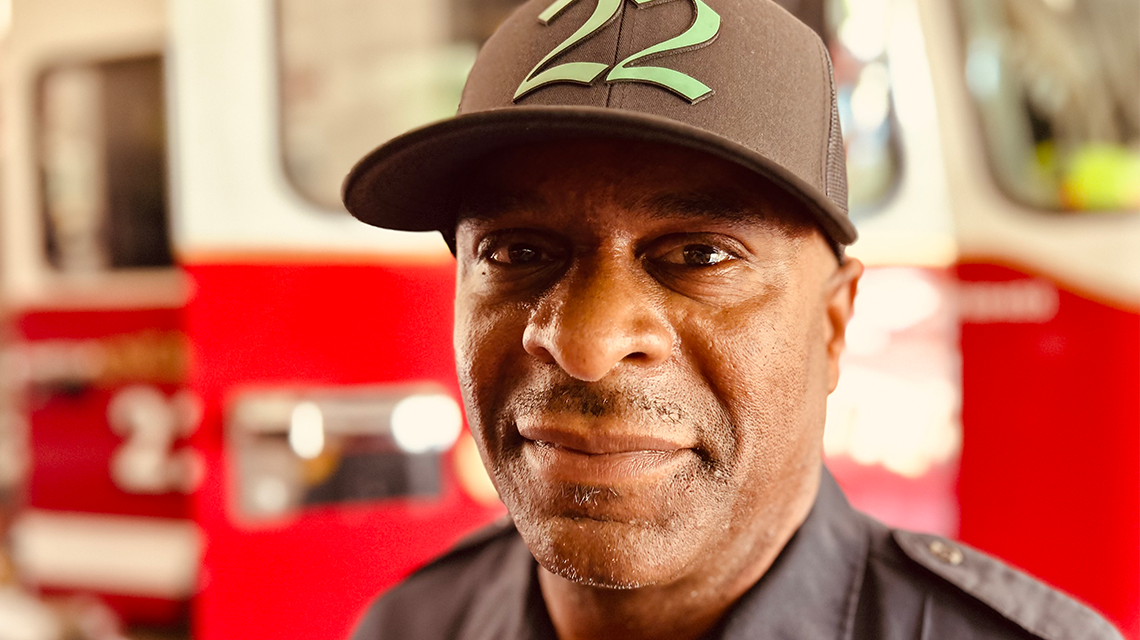 Brian Rodman stands in front of Engine 22, reflecting on his fight with prostate cancer and the support that carried him through the toughest moments of his life. 