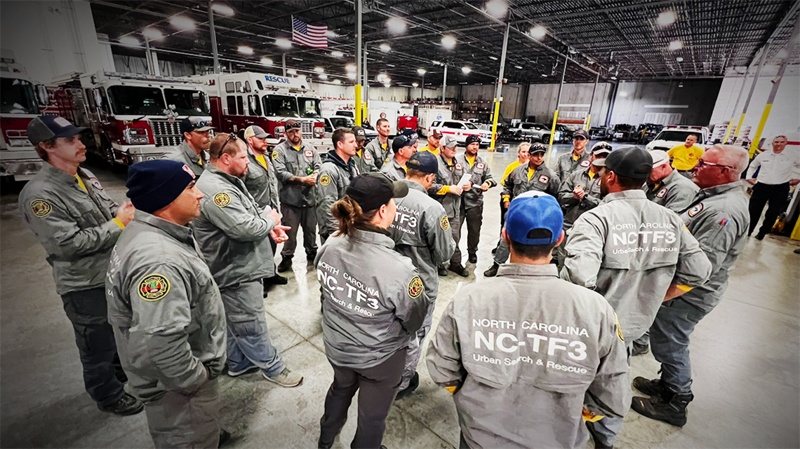 Charlotte Fire Urban Search and Rescue team gathers for a final briefing and debriefing after returning home from their deployment to Yancey County, where they worked alongside other agencies to assist in recovery efforts following Hurricane Helene