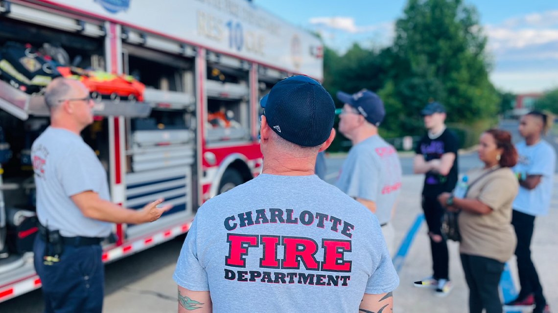  Participants listen as a Charlotte Fire member explains the tools and equipment stored on a heavy rescue apparatus during week two of the Citizen Fire Academy. 