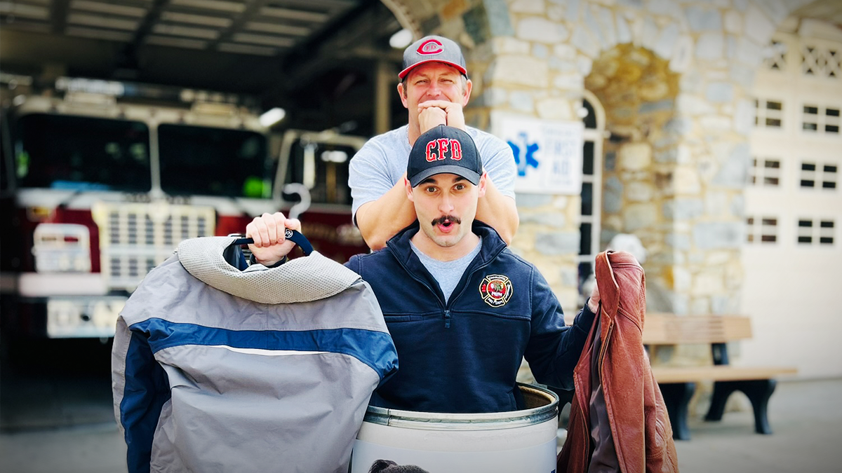 Two Charlotte Fire firefighters collect coats at Firehouse 6, demonstrating the department's commitment to keeping kids warm and supported