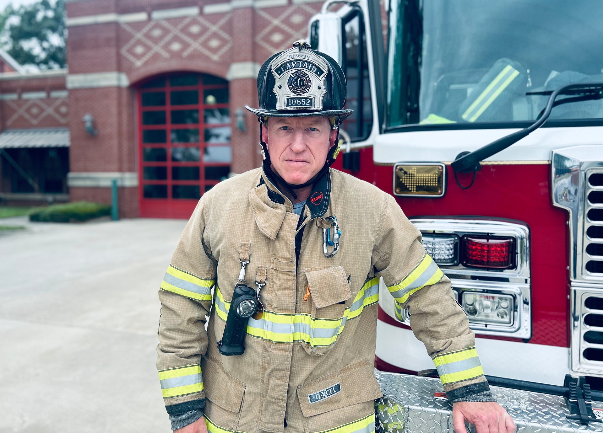 Bowman in full turnout gear at Firehouse 10, standing beside Engine 10, ready to answer the next call and represent Charlotte Fire’s strength and skill.