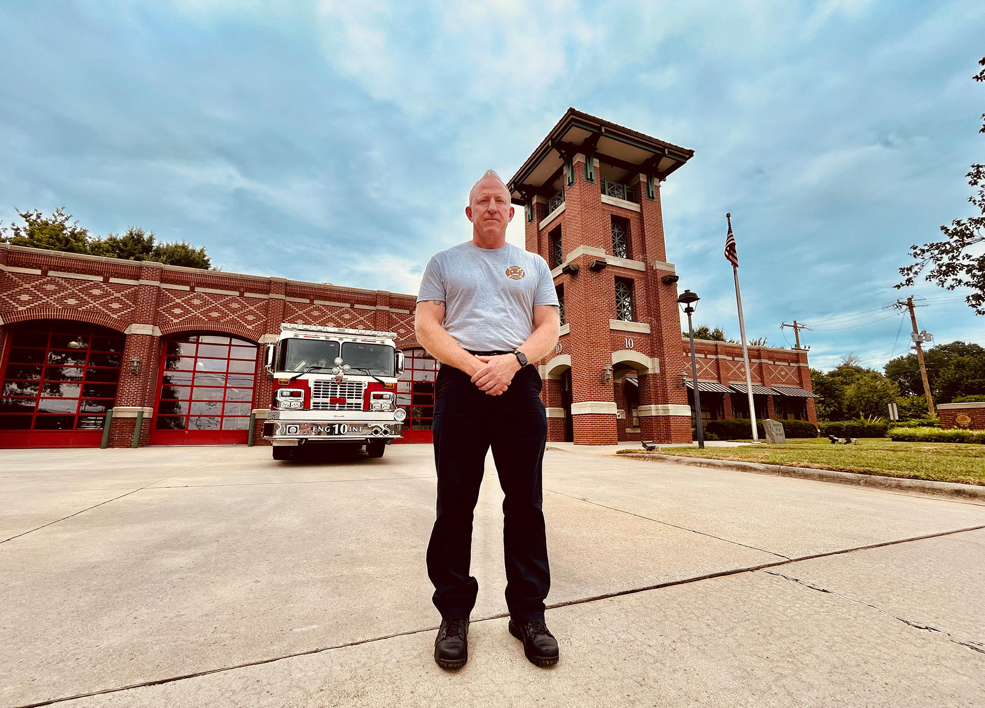 The veteran firefighter stands in front of Firehouse 10, a place he calls home as both a firefighter and a world-class competitor. 