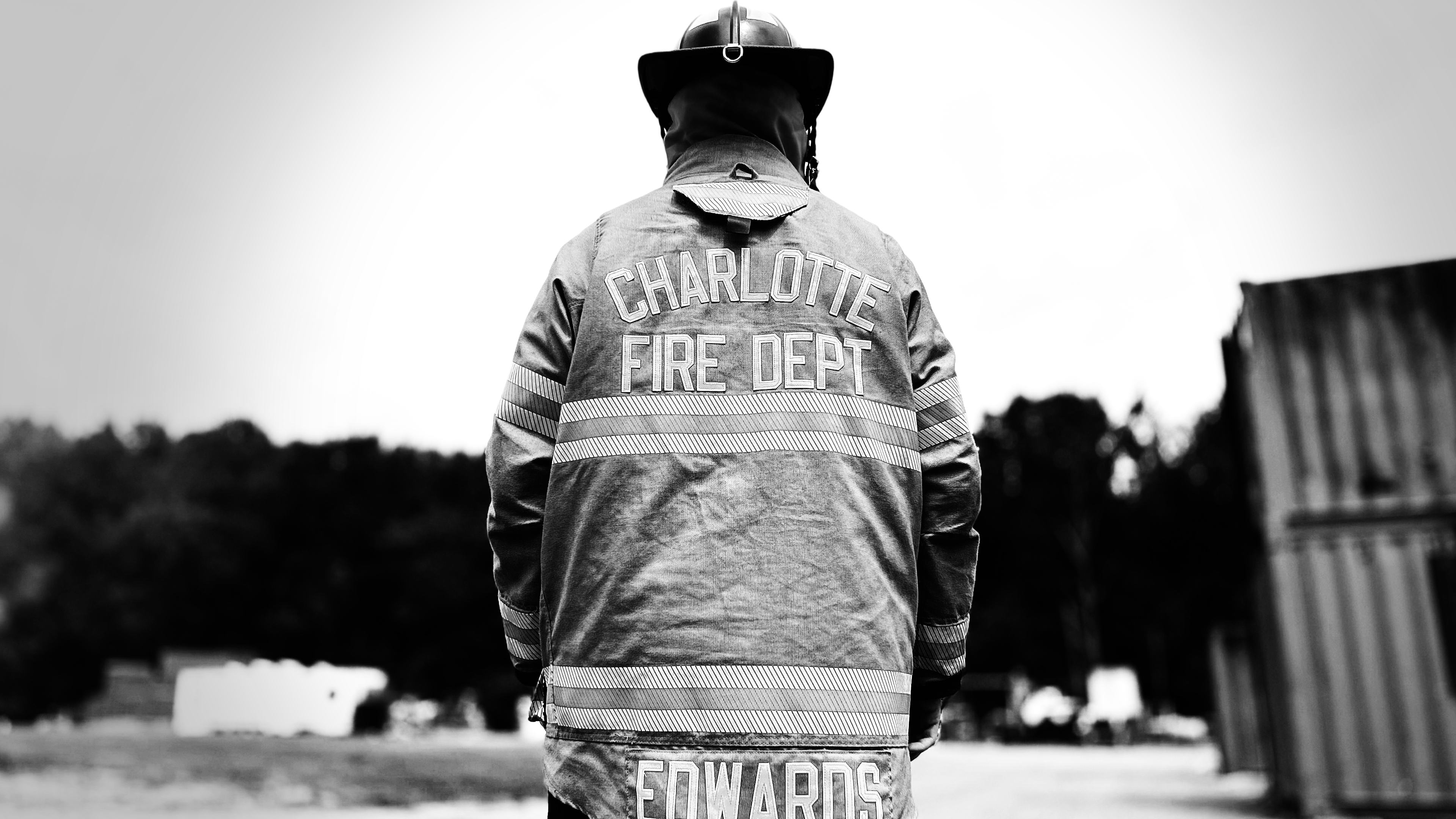 Back turned to the camera, Edwards wears the name of his new calling. Charlotte Fire—the department where his training became action. 