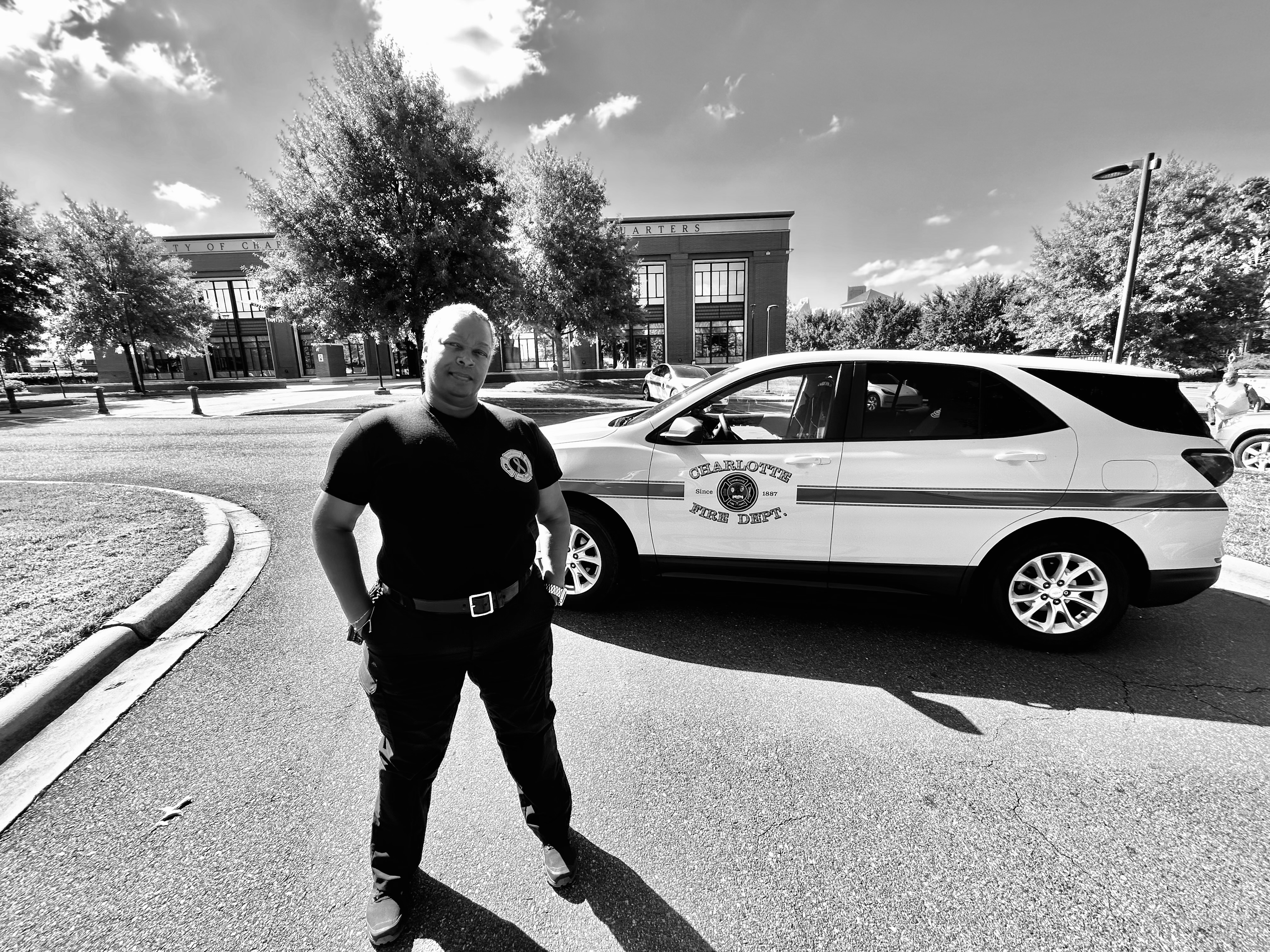 Captured in black and white, Reynolds stands alongside her Charlotte Fire vehicle, representing the department that has supported her through her cancer journey.