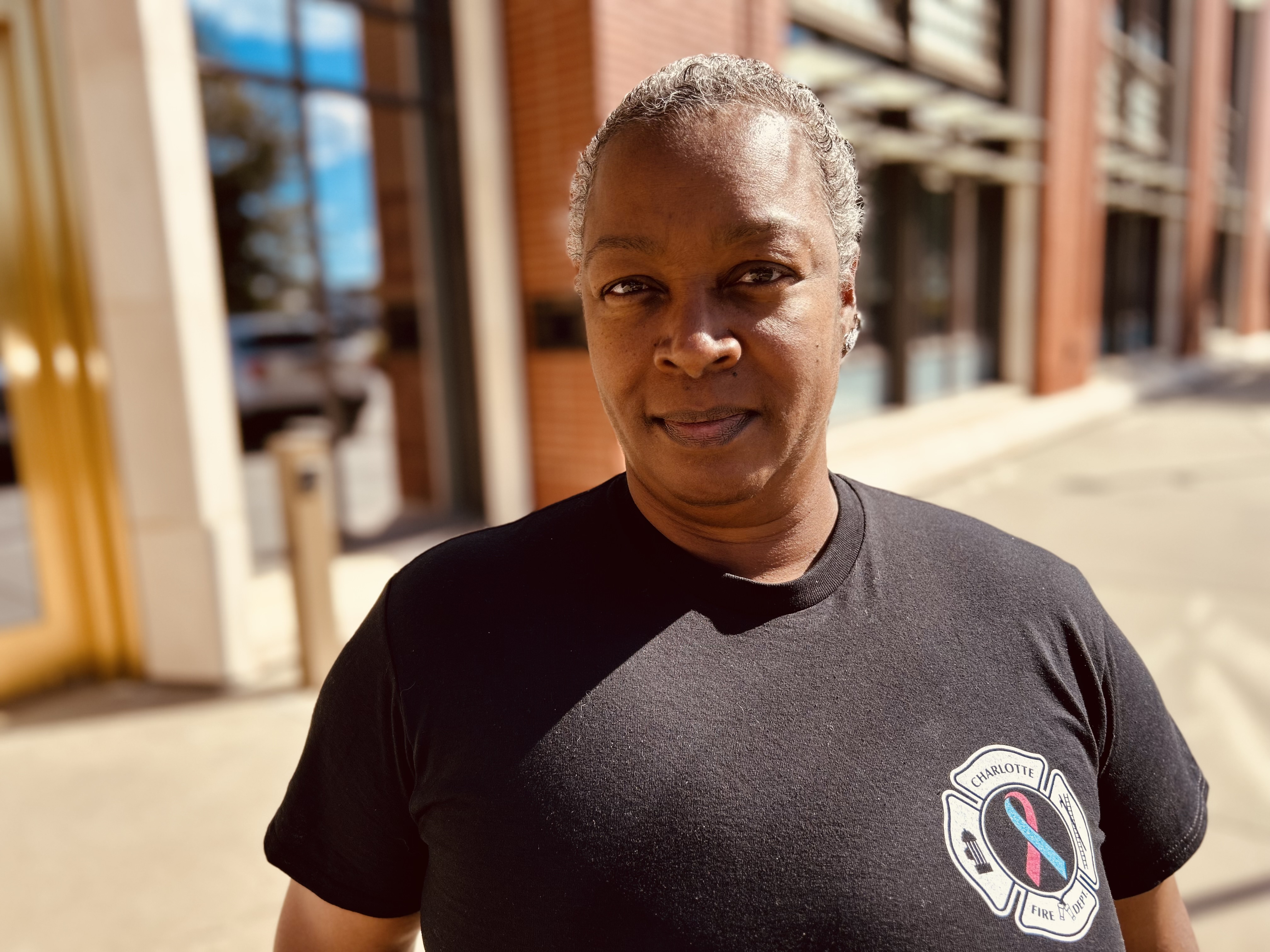 Reynolds outside Charlotte Fire Headquarters, wearing the department’s Breast Cancer Awareness emblem close to her heart. 