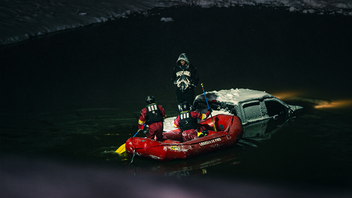 Charlotte Fire rescue personnel use a boat to access a vehicle in the water during a winter incident. 