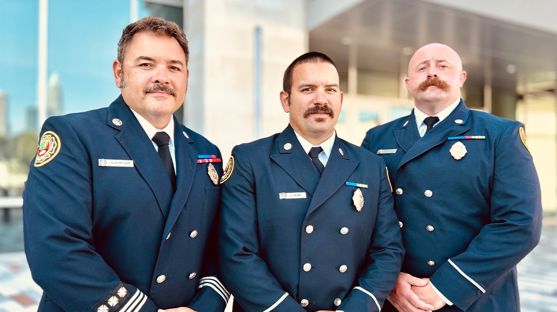 Charlotte Fire’s Engine 15 crew members Engineer Justin Barringer, Firefighter Jonathan Moore, and Firefighter William Costello stand together after receiving The Order of the Long Leaf Pine