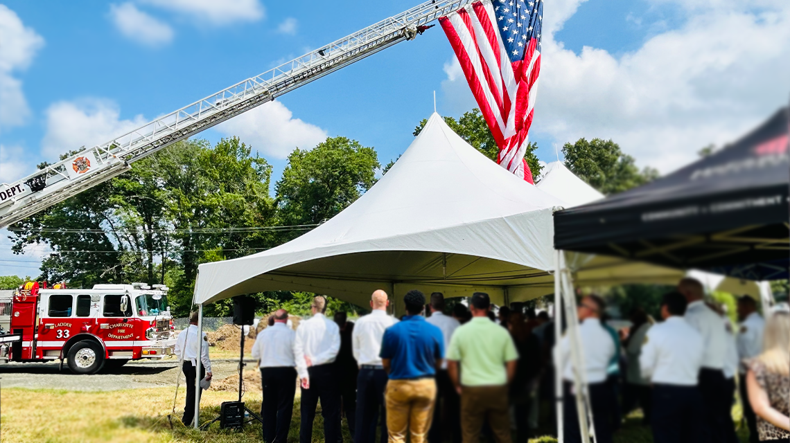 Underneath a massive American flag, community members and Charlotte Fire personnel gathered for the groundbreaking ceremony marking the start of construction for Firehouse 46. 