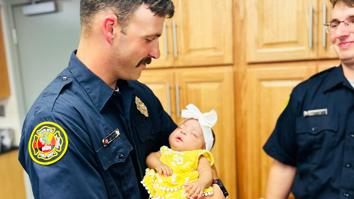 Firefighter Stephen Taylor holds baby Leilani, who was born with the help of Charlotte Fire crews from Engine 21 during a surprise home delivery earlier this year. 