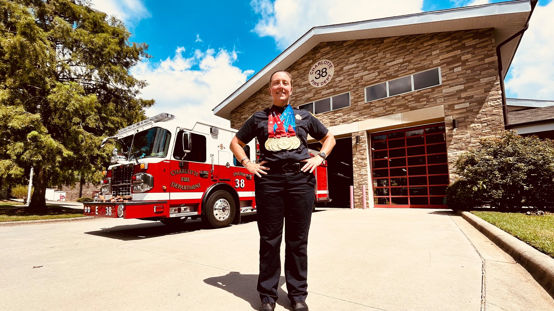 Holly Forbes Johnson stands proudly outside Firehouse 38, wearing her six gold medals earned at the World Police & Fire Games in Birmingham, Alabama.