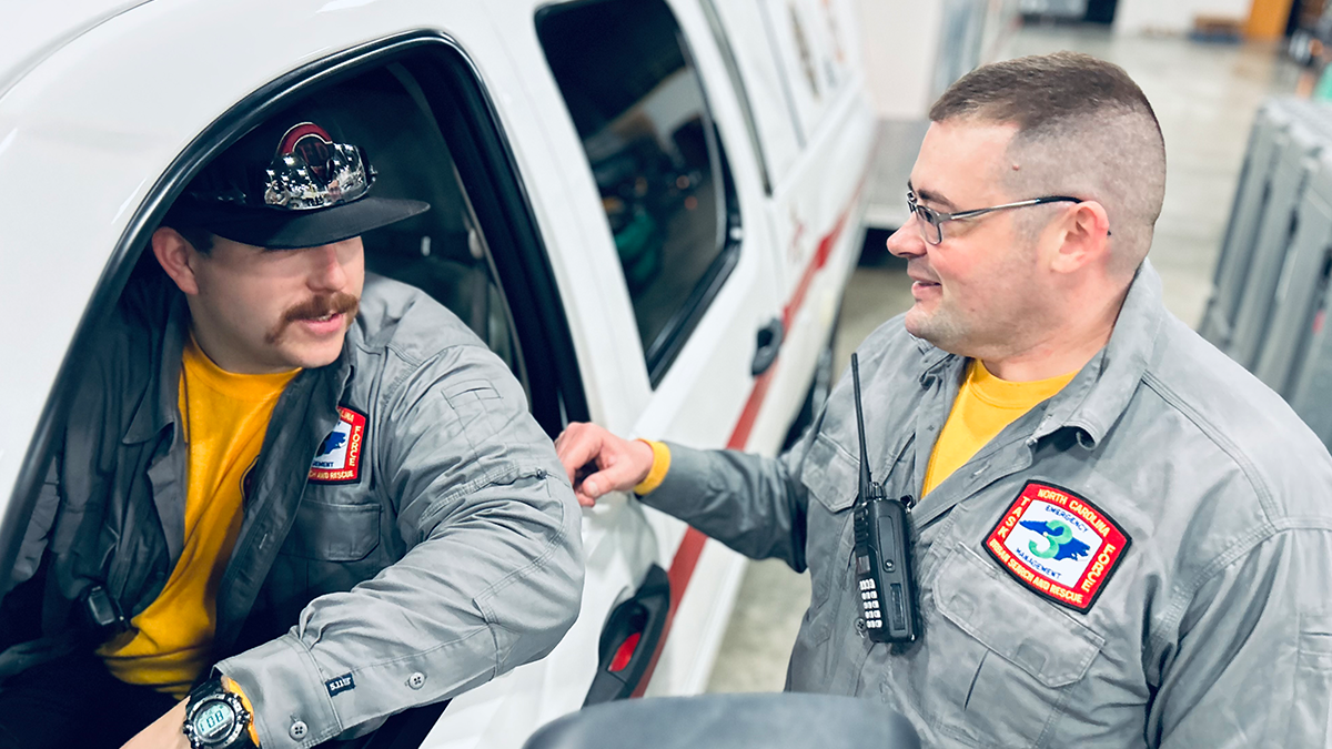 Crews coordinate final field communications before deployment, ensuring their swift water rescue equipment and response plans are ready for the mission in Kentucky.