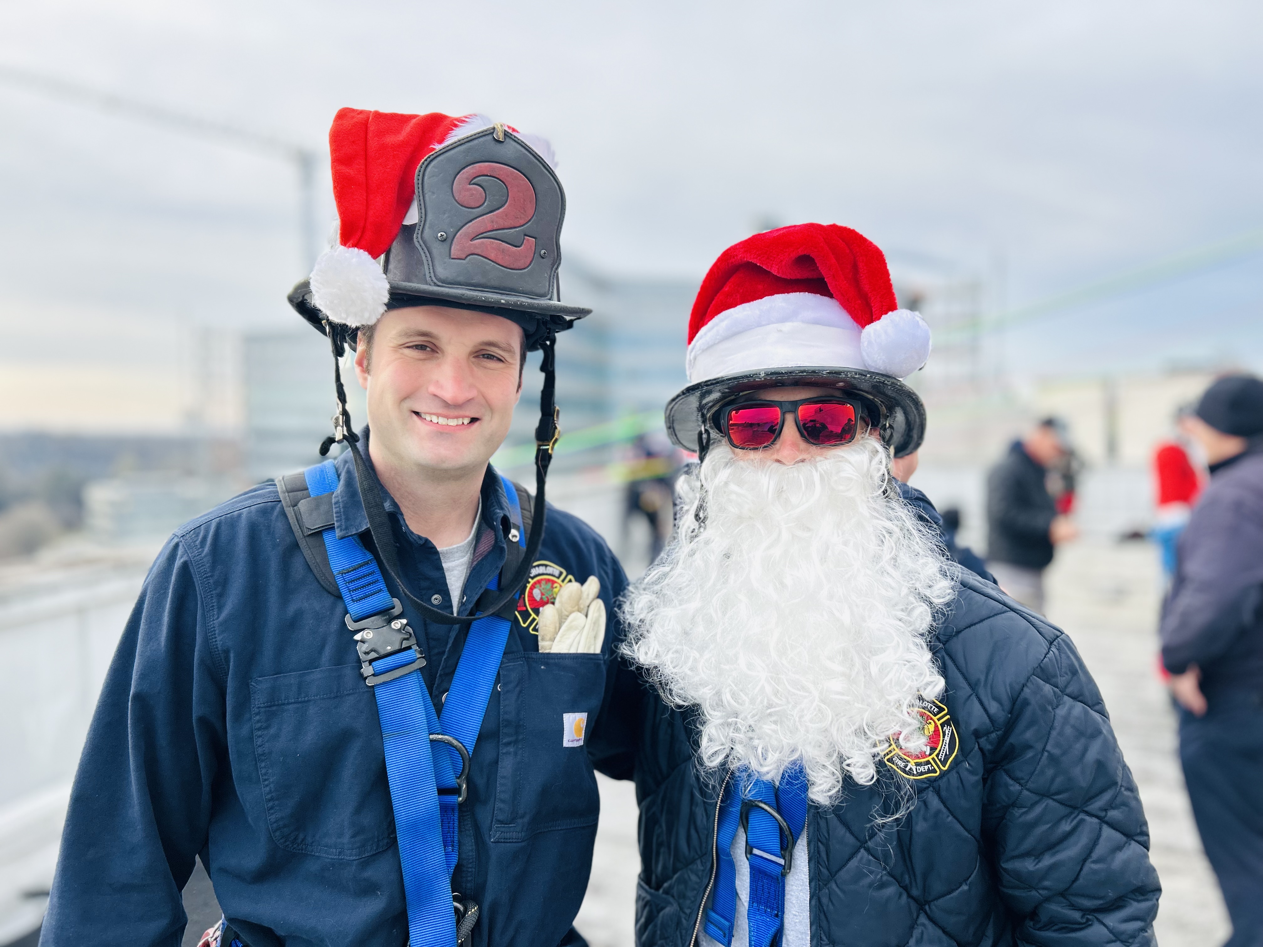 Firefighter camaraderie meets Christmas spirit as Charlotte Fire crewmembers top off their gear with Santa hats before heading over the edge at Levine Childrens Hospital. 