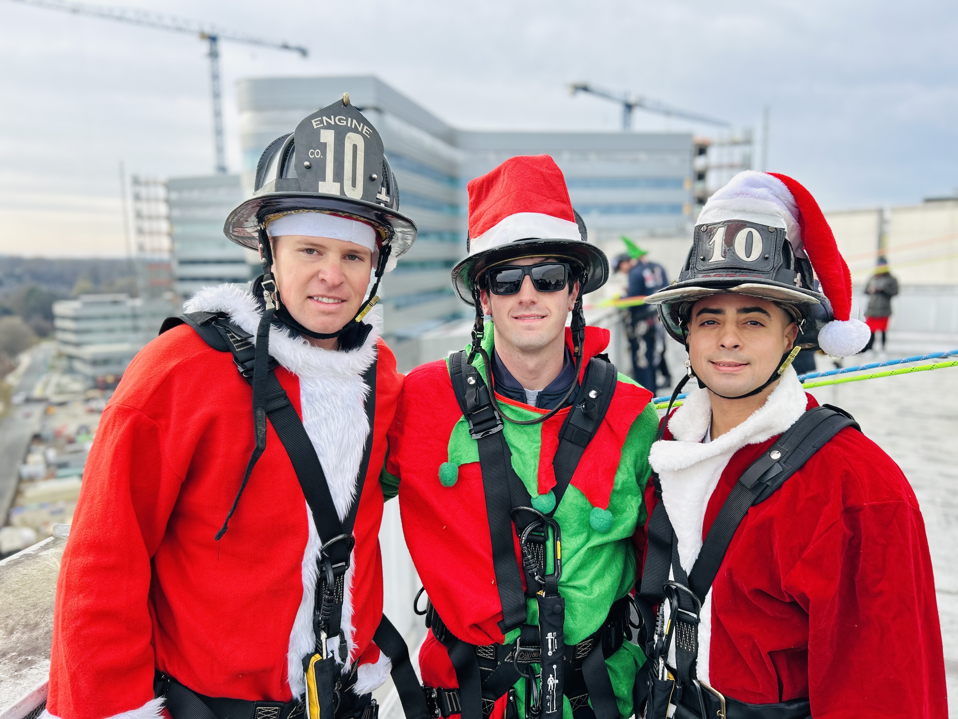 Decked out in holiday flair, Charlotte Firefighters from Engine 10 gather on the rooftop before their descent. For many of them, this is the best day of the year 