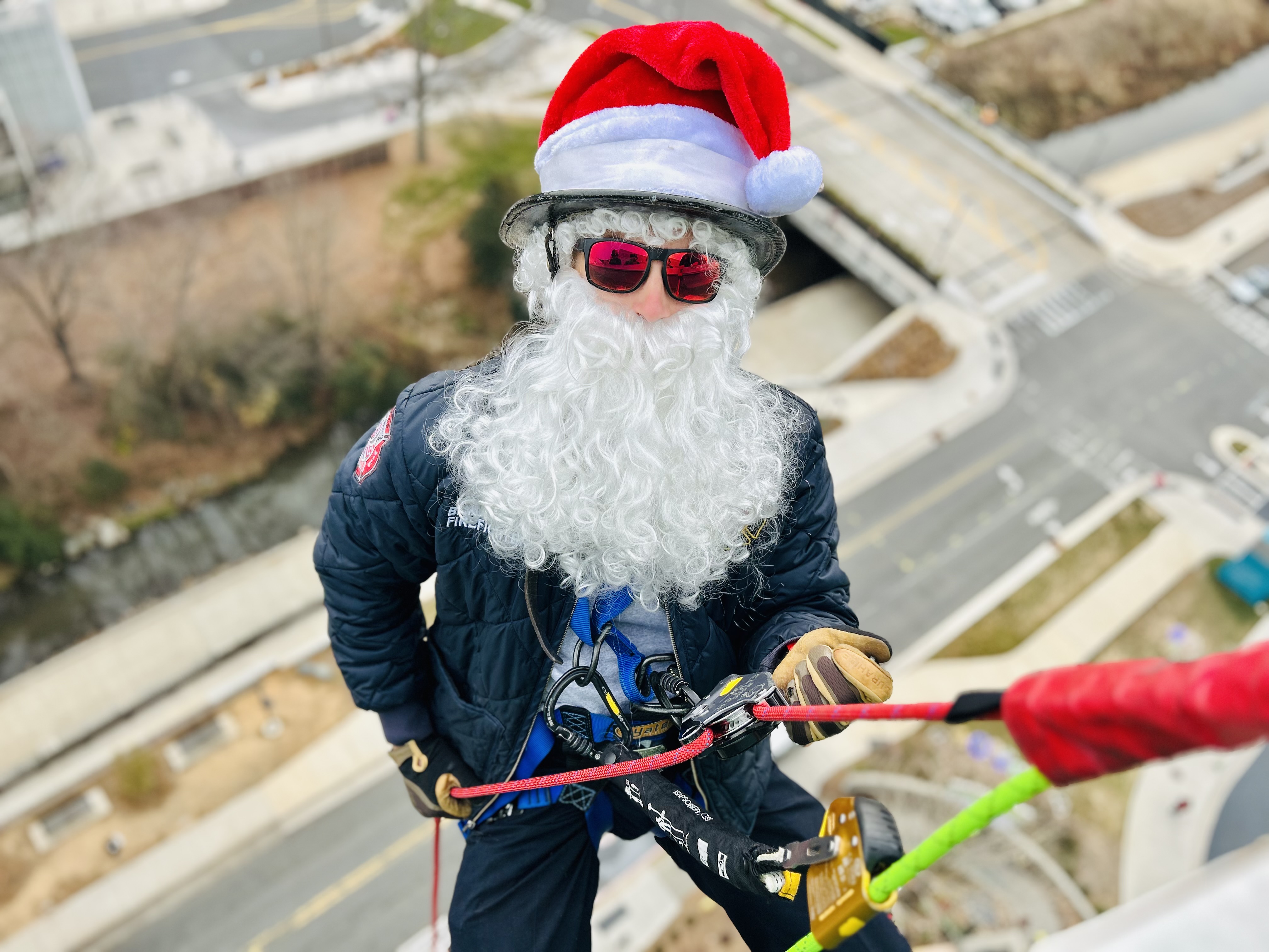 Firefighter Brandon Mulligan trades turnout gear for a Santa suit and rappelling harness, bringing smiles to Levine Childrens one window at a time.