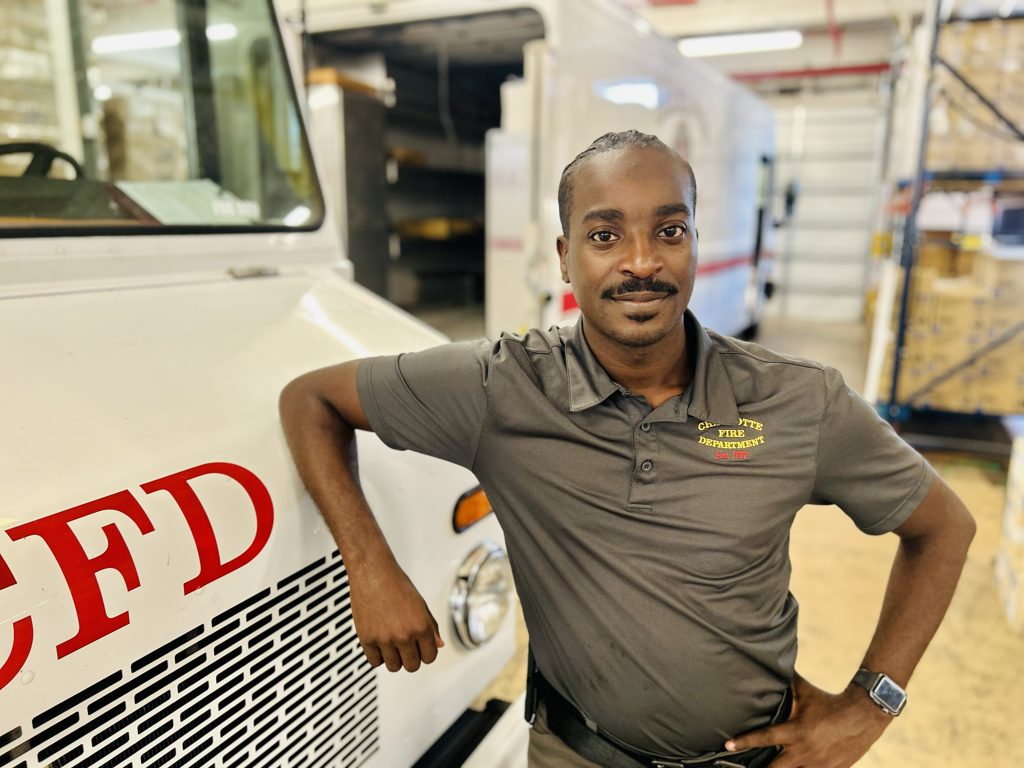Charlotte Fire’s Facilities Services Coordinator Malik Burkett stands inside the department’s Logistics Division, where his leadership helps keep operations efficient and firefighters equipped for every call.