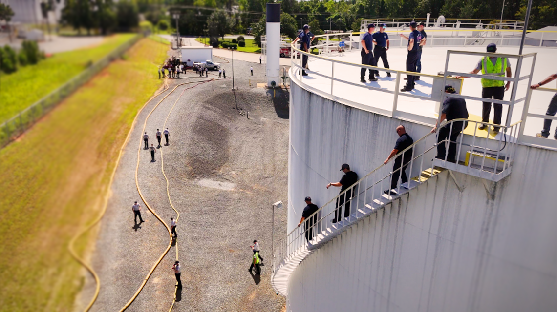 Charlotte Fire firefighters descend stairs along the exterior of a fuel storage tank during a training operation at Tank Town. 
