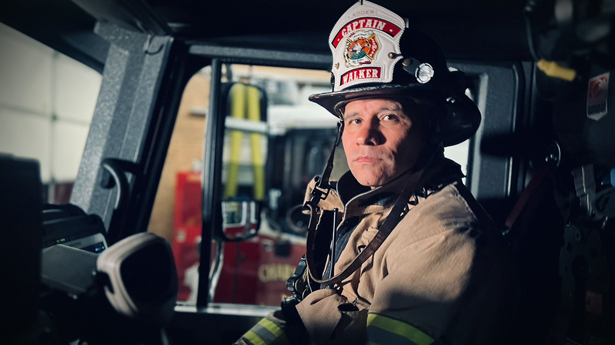 Captain Matthew Walker in full gear, seated in the cab of Ladder 16, ready to lead his crew into action and serve the community.