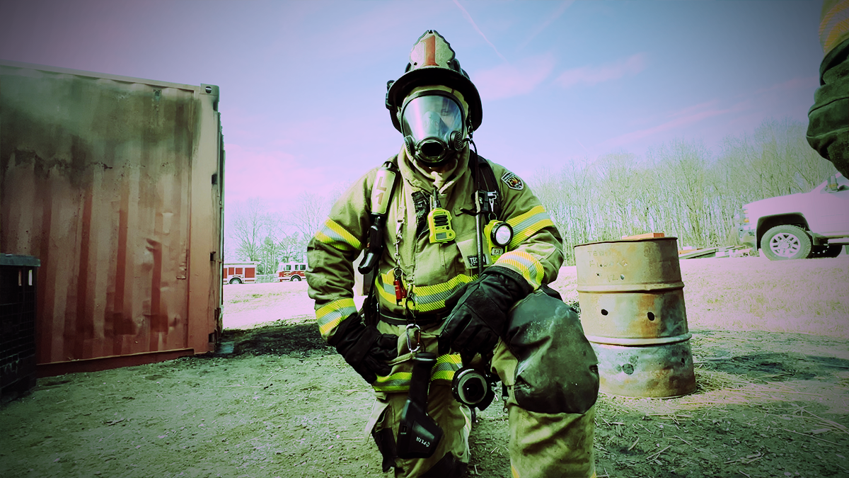 Fully geared and kneeling before a training scenario, Watts embodies the readiness and resilience demanded by the job. 