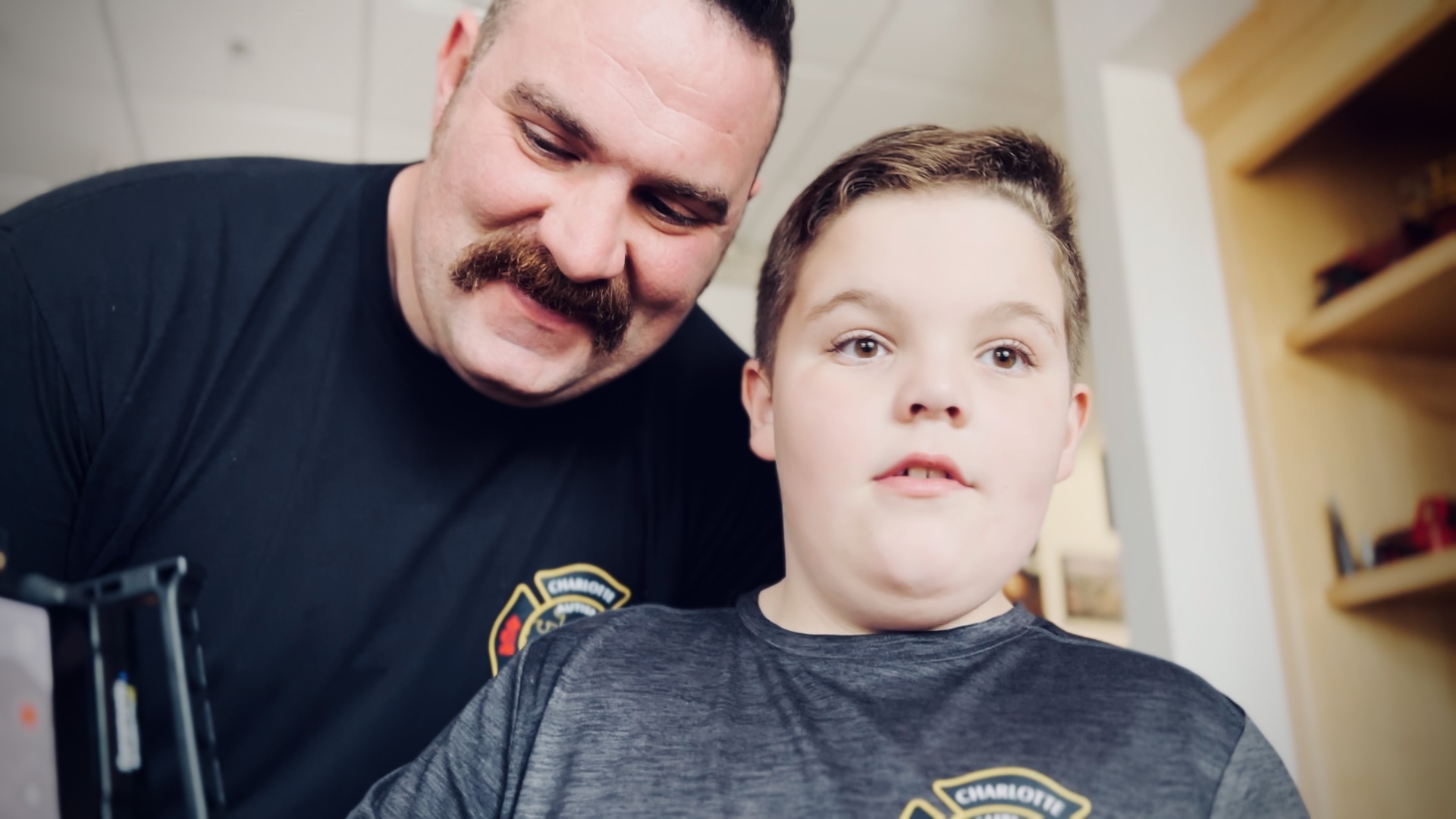 Firefighter Nate Powell leans in close beside his son, Benjamin, during a quiet moment together. 