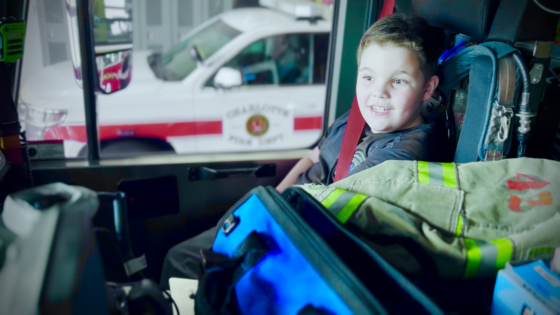 Benjamin Powell sits buckled into the captain’s seat inside an Engine 42 cab during a visit to Firehouse 42. 
