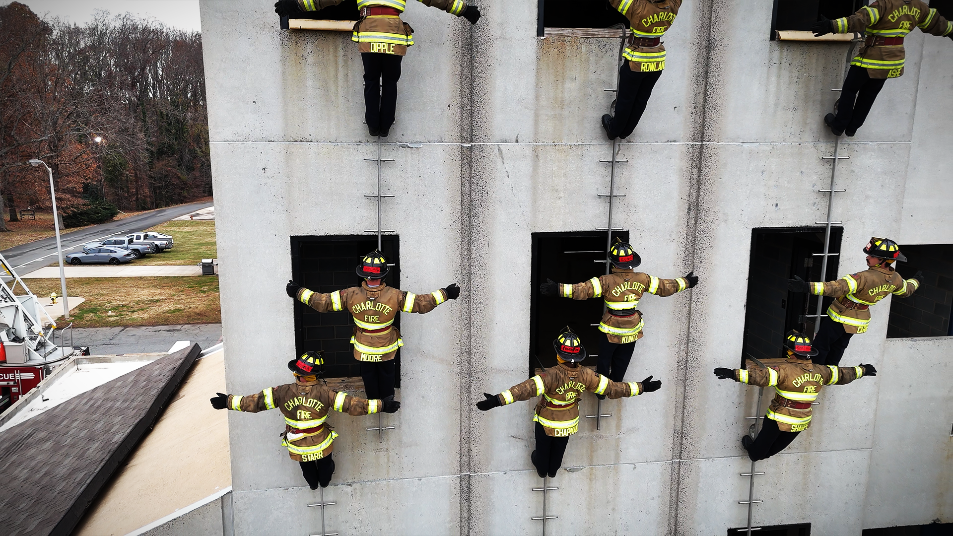 Recruits hold their positions along the wall, demonstrating balance, control, and the teamwork that defines this exercise. 