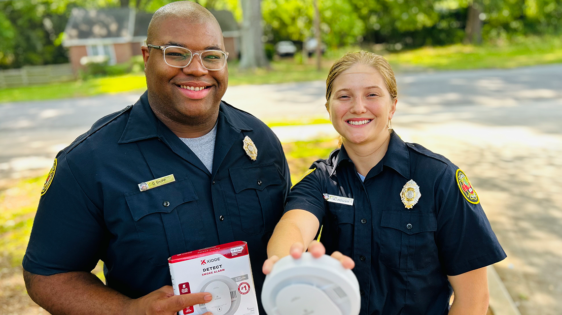 Crews from Engine 15 work together during Smoke Alarm Saturday, installing free alarms and talking with residents about fire safety at home.