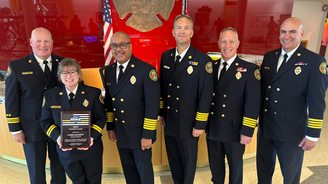 Melissa Lounsbury stands with Charlotte Fire Communications Superintendent and Command Staff after receiving the North Carolina NENA President’s Award. 