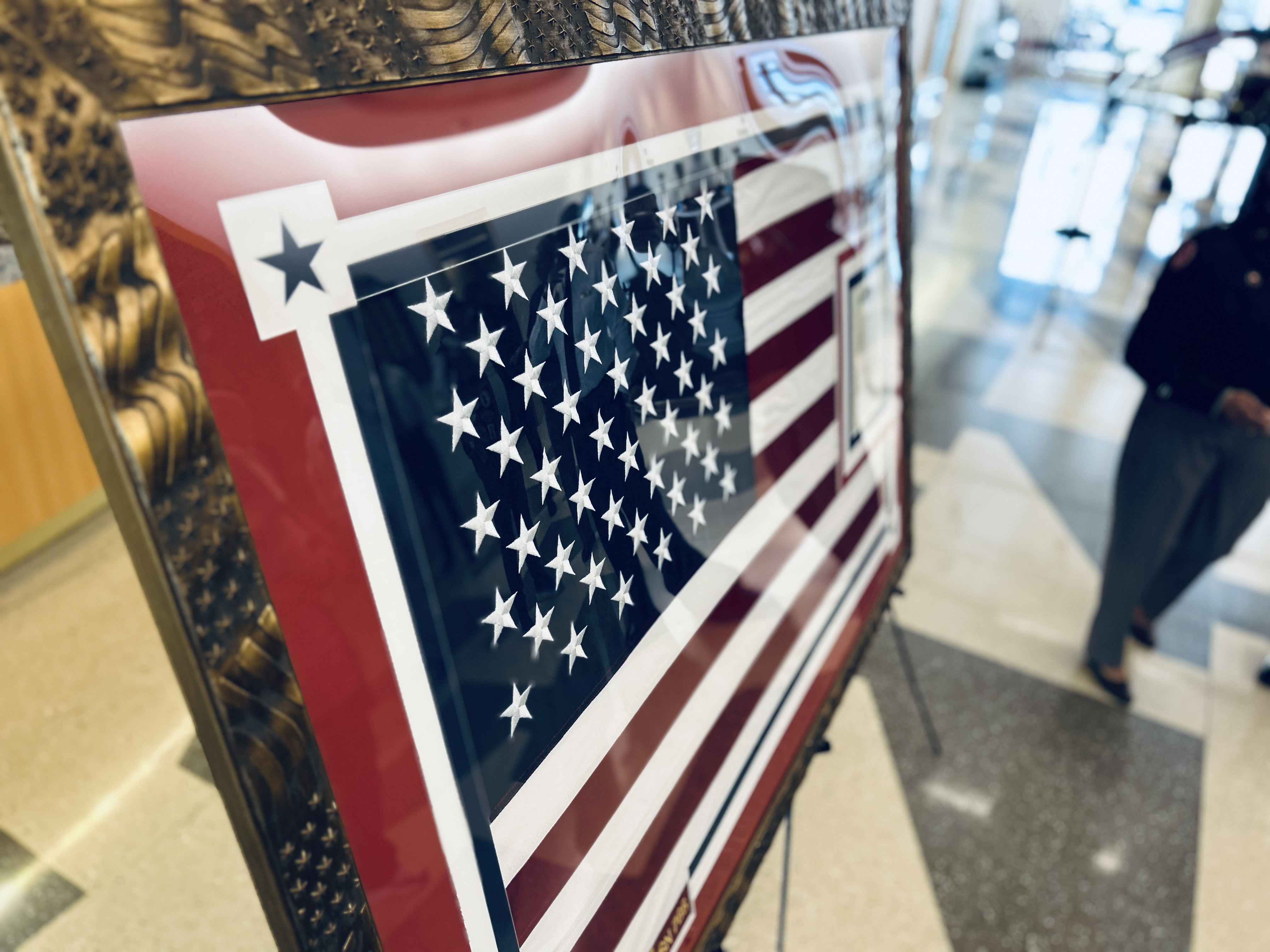 A close-up view of the U.S. Navy Ensign flown aboard the USS Charlotte highlights the detail of the custom frame and presentation at Charlotte Fire Headquarters. 