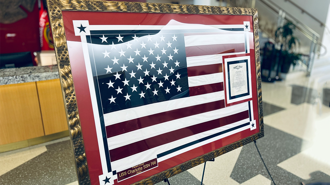 The framed U.S. Navy Ensign flown aboard the USS Charlotte is displayed at Charlotte Fire Headquarters following the formal dedication ceremony.  