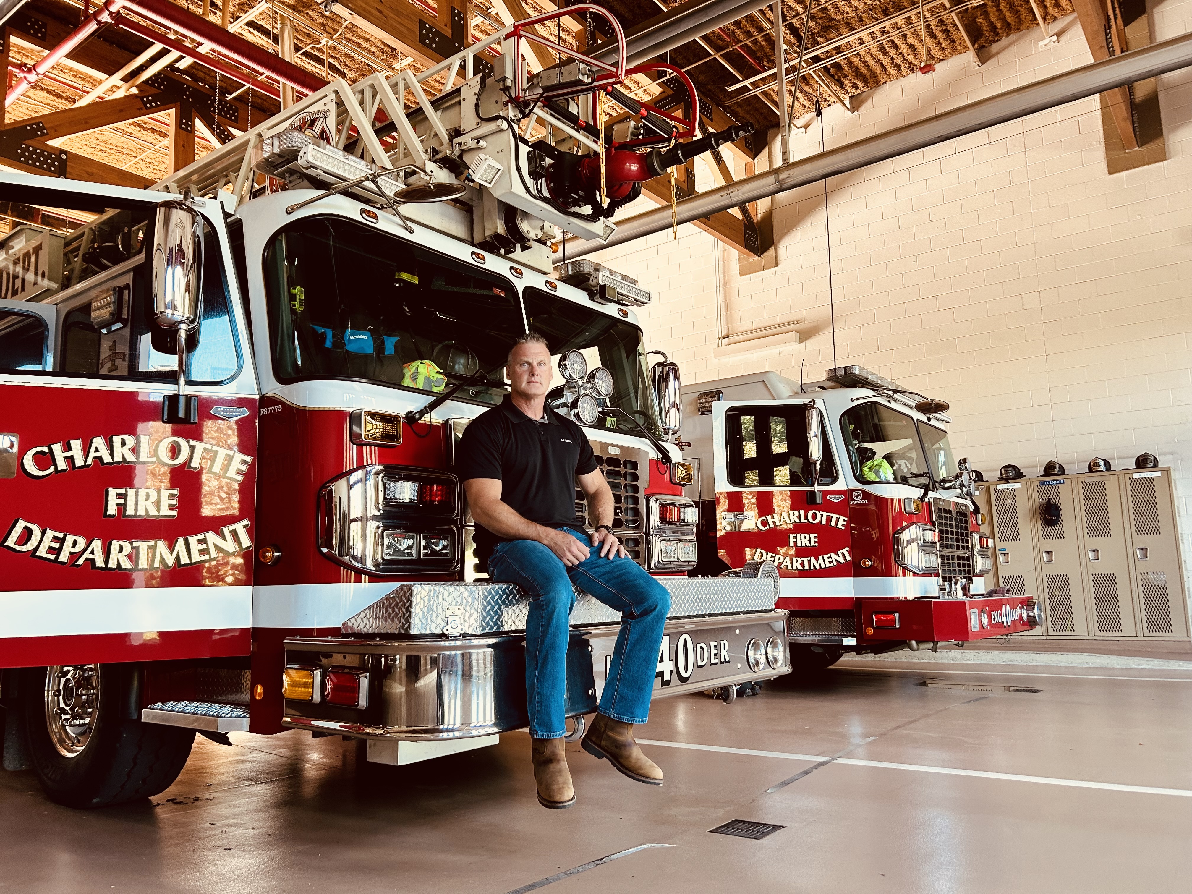Seated on the bumper of a fire truck, Walker reflects on both his firefighting career and the challenges of cancer recovery. 
