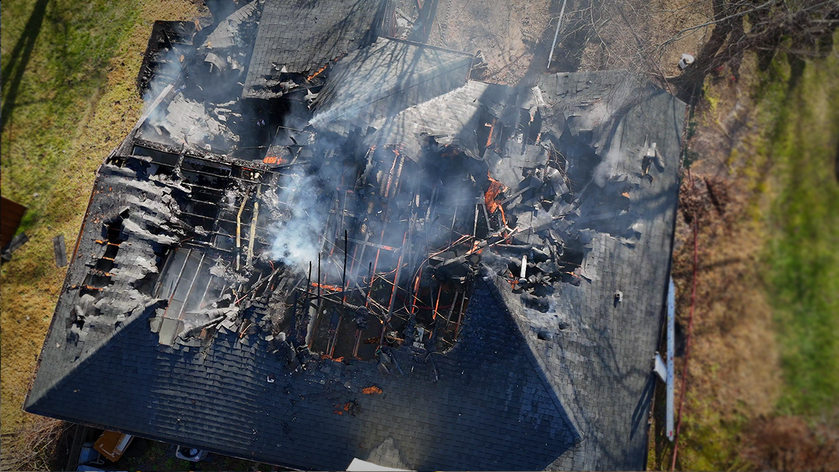 Aerial view of the extensive damage caused by the Harris Ridge house fire. Firefighters were able to bring the fire under control despite structural challenges.