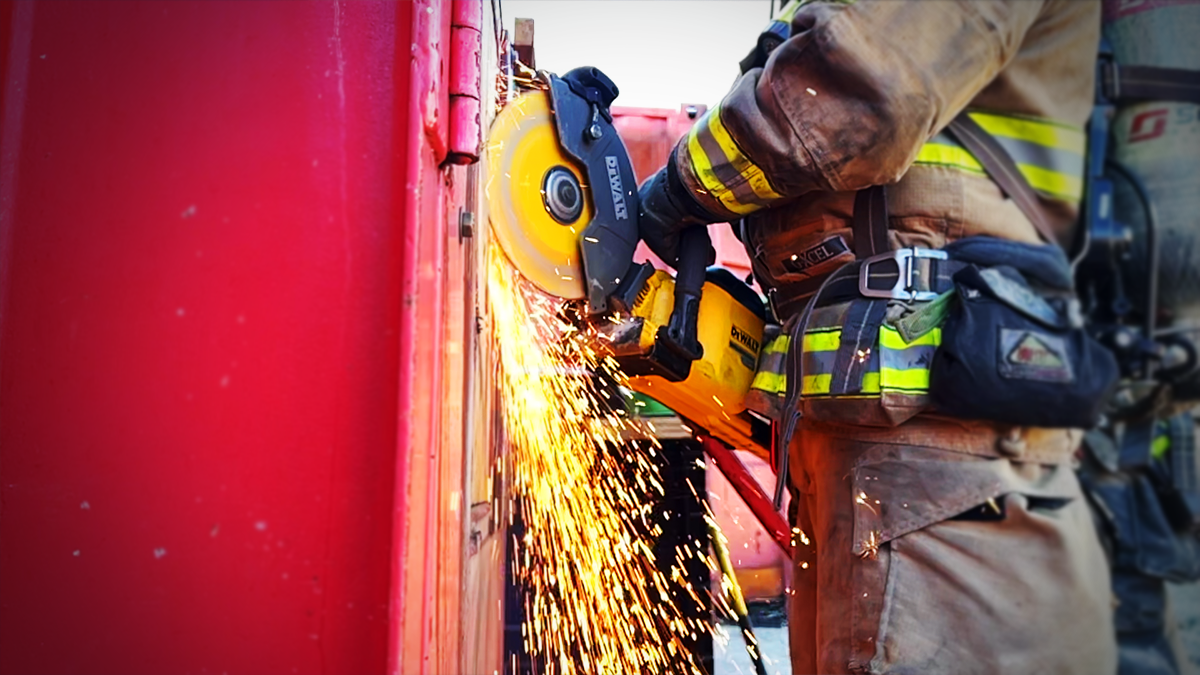 Sparks fly as a firefighter demonstrates forcible entry techniques, a vital skill for navigating barriers during emergencies.