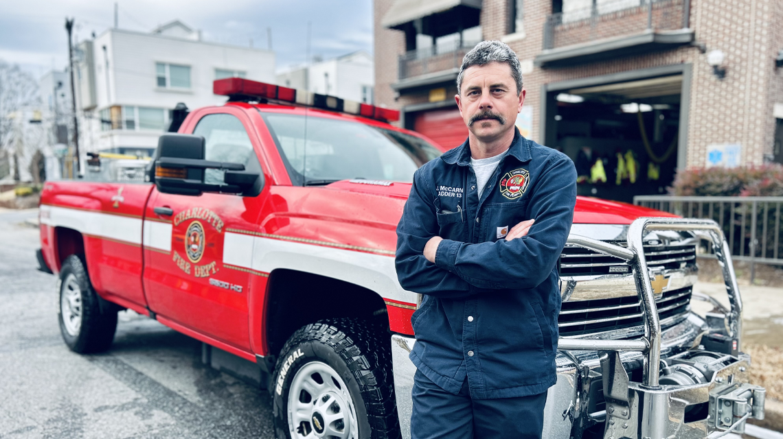 Charlotte Fire Captain Jarad McCarn stands with a brush truck staged for winter weather operations. 