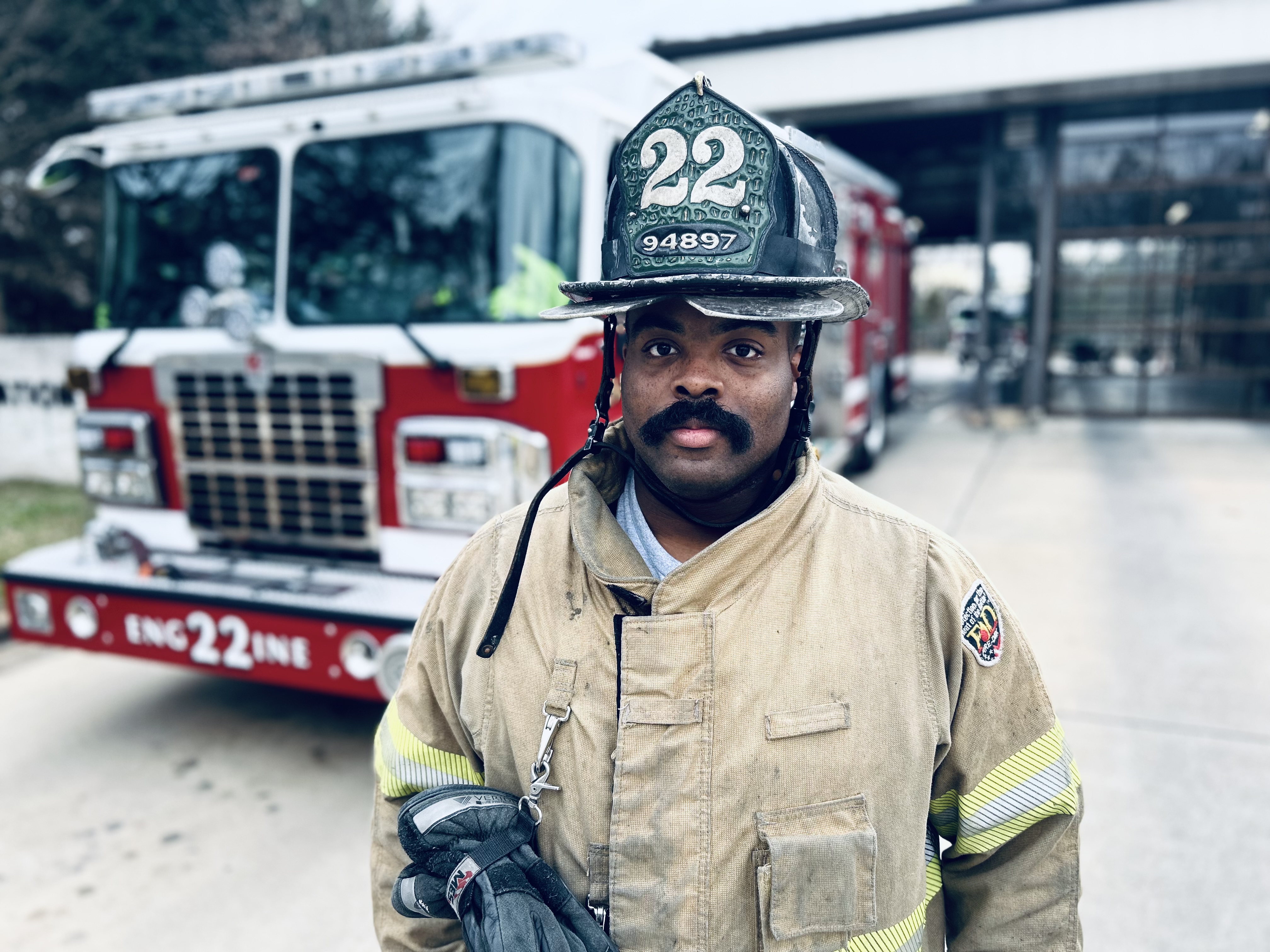 Charlotte Firefighter Jacob Hanes stands in front of Engine 22 as crews prepare for increased call volume during winter weather.