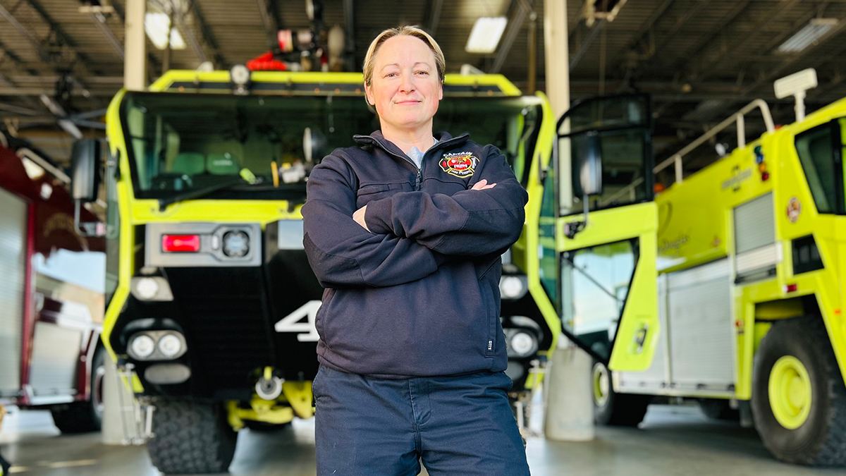 With the specialized airport fire apparatus behind her, Captain Law stands with confidence—ready to respond to any emergency with skill and experience.