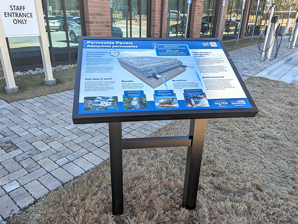 At the One Water Facility, the Permeable Pavers sign is positioned next to the stormwater control measure. 